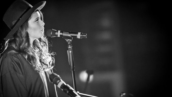 Die italienische Sängerin Francesca Michielin mit Hut singt am Mikrofon und blickt nach oben © Sony Music Italy / Francesco Prandoni 