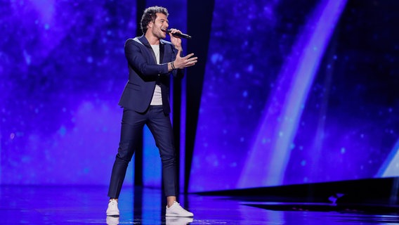 Amir steht im dunkelblauen Anzug auf der Bühne. © eurovision.tv Foto: Andres Putting (EBU)