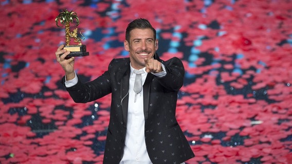 Francesco Gabbani mit seiner Sieges-Trophäe beim Sanremo Festival 2017 © Picture-Alliance / Pacific Press Foto: Pamela Rovaris