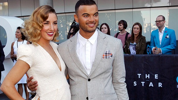 Der australische Sänger Guy Sebastian posiert mit seiner schwangeren Frau Jules für die Fotografen bei den Aria Awards 2013. ©  picture alliance / dpa Foto: Quentin Jones