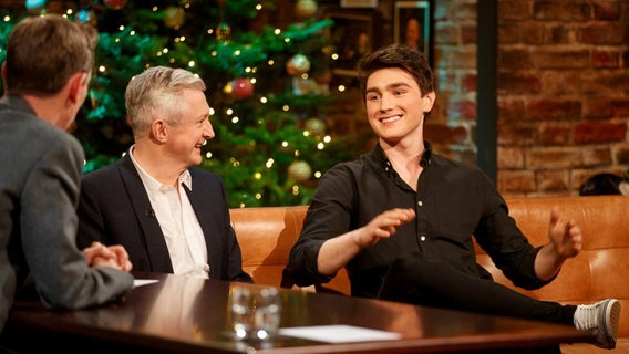 Brendan Murray und sein Manager Louis Walsh auf einem Sofa sitzend vor einem Tannenbaum im Studio der "Late Late Show" in Irland © RTÉ 