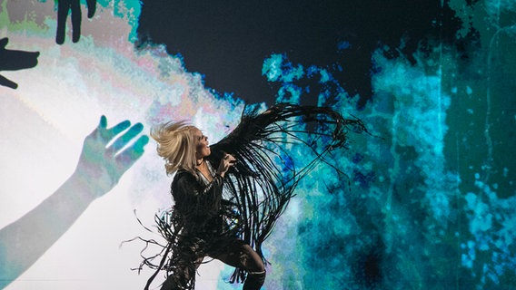 Gréta tritt in einem schwarzen Lederkostüm mit Fransen auf. © eurovision.tv Foto: Andres Putting (EBU)