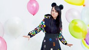 Sängerin Jamie-Lee Kriewitz steht mit buntem Kleid und Plüschohren inmitten von Luftballons. © Universal Music 