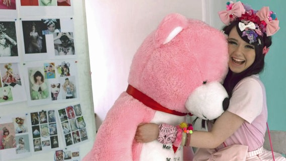 Jamie-Lee hat einen riesigen rosa Teddy im Arm.  