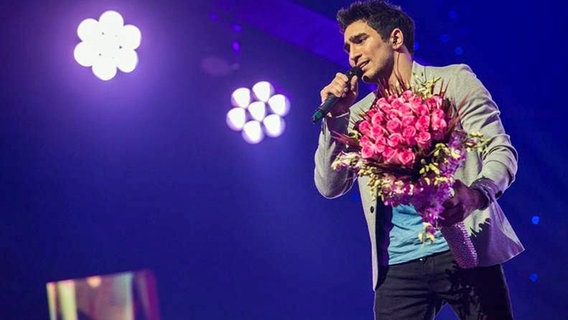 Farid Mammadov bei einem Auftritt mit einem Blumenstrauß in der Hand. © NDR Foto: Rolf Klatt