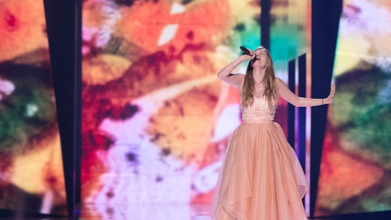 Zoë singt und streckt ihren Arm auf der Bühne aus. © eurovision.tv Foto: Andres Putting (EBU)