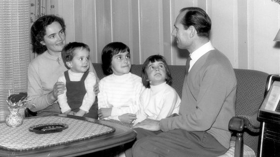 Paola Felix sitzt 1959 zusammen mit ihren Eltern und zwei Geschwistern auf einem Sofa. Alle gucken den Vater an. © Paola 