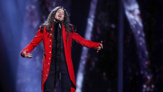 Michał Szpak trägt eine rote Jacke auf der Bühne. © NDR/Rolf Klatt Foto: Rolf Klatt