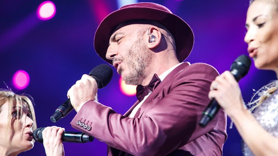 Serhat tritt im burgunderfarbenen Anzug mit dazu passendem Hut auf. © eurovision.tv Foto: Thomas Hanses (EBU)