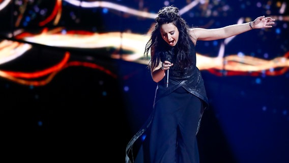 Jamala beugt sich nach vorn und streckt den Arm aus. © eurovision.tv Foto: Andres Putting (EBU)
