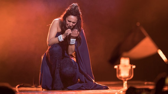 Jamala aus der Ukraine kniet singend vor dem Siegerpokal. © NDR Foto: Rolf Klatt