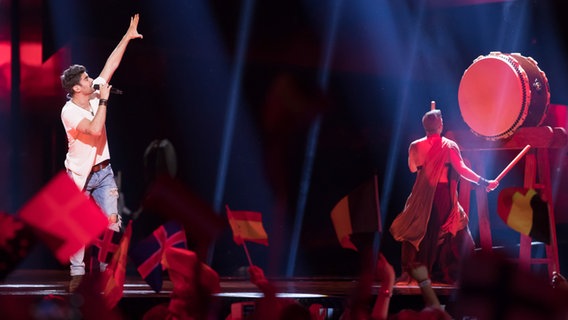 Freddie aus Ungarn zeigt mit einem Arm nach oben, auf der Bühne steht ein Trommler mit dem Rücken zum Publikum © NDR Foto: Rolf Klatt