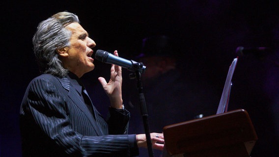 Toto Cutugno singt am Klavier bei einem Auftritt in Novosibirsk 2010.  