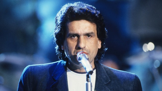 Toto Cutugno singt ins Mikrofon.  