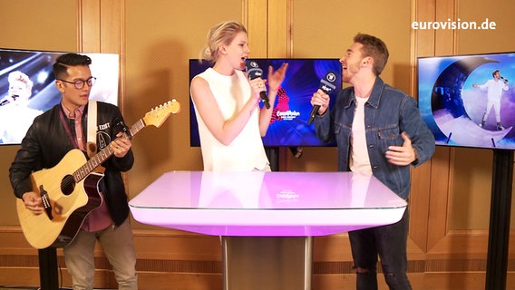 Die deutsche ESC-Teilnehmerin Levina, der österreichische ESC-Teilnehmer Nathan Trent und ein Gitarrist im Studio © NDR 