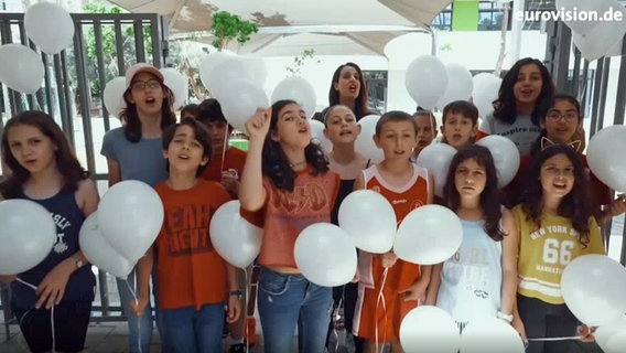 Kinder in einer Schule in Tel Aviv halten weiße Luftballons in den Händen und singen. © NDR 