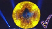 Der litauische Sänger Jurijus steht in einem Feuerball auf der Bühne und singt.  