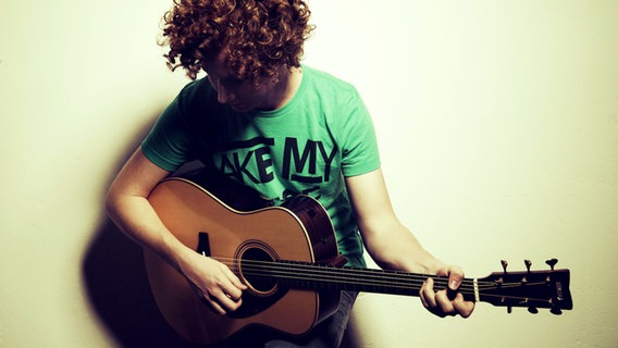 Der Sänger Michael Schulte spielt Gitarre  Foto: Sven Sindt